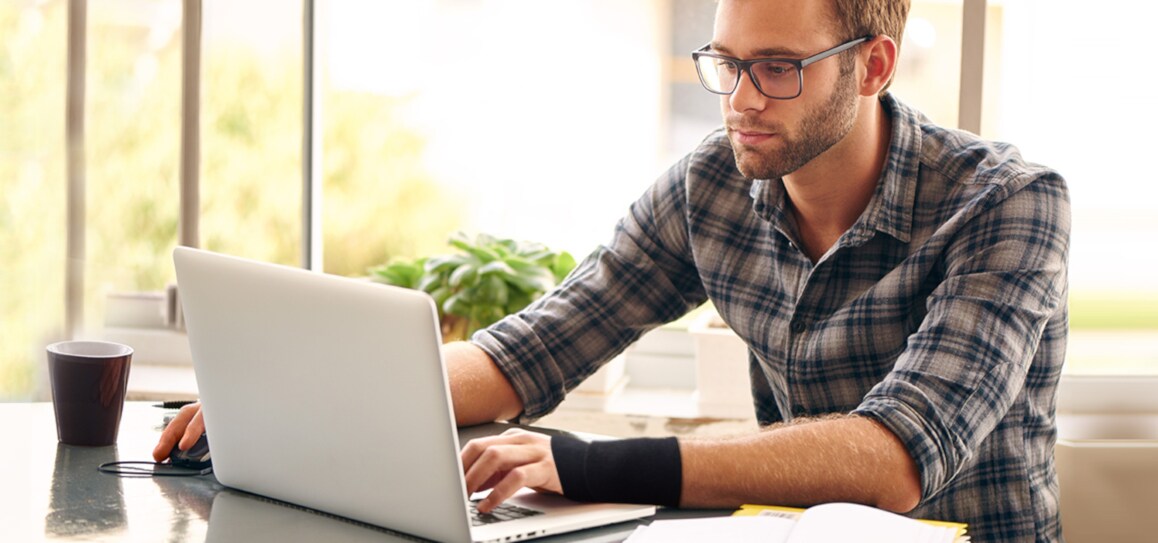 laptopon gépelő férfi csuklórögzítővel